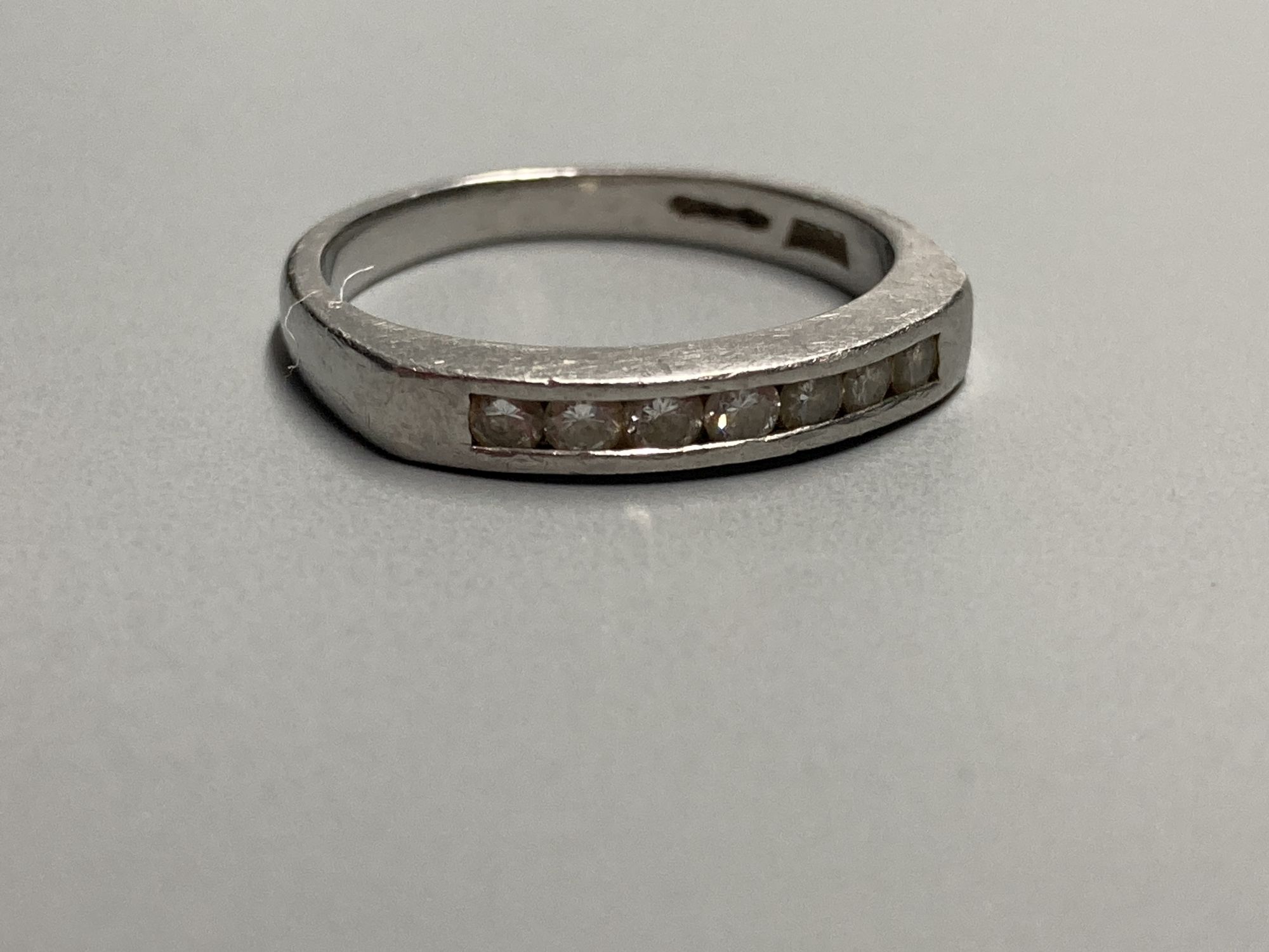 A modern platinum and channel set seven stone diamond half hoop ring, size K/L, gross 4 grams.